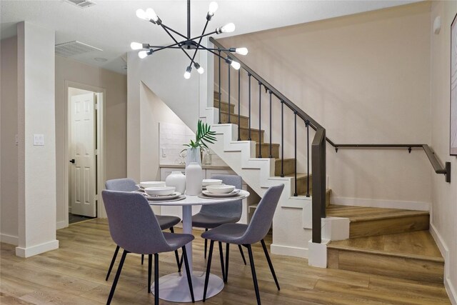 4507 Elana Ct, Austin, TX 78741 - dining area featuring a chandelier, stairway, baseboards, and wood finished floors