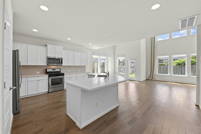 6724 Leonardo Dr, Round Rock, TX 78665 - kitchen featuring appliances with stainless steel finishes, dark wood finished floors, light countertops, tasteful backsplash, and recessed lighting