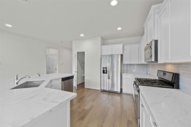 6724 Leonardo Dr, Round Rock, TX 78665 - kitchen featuring stainless steel appliances, a sink, light wood-style flooring, backsplash, and white cabinets