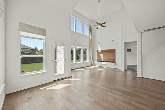 6724 Leonardo Dr, Round Rock, TX 78665 - unfurnished living room with ceiling fan, wood finished floors, a towering ceiling, and baseboards