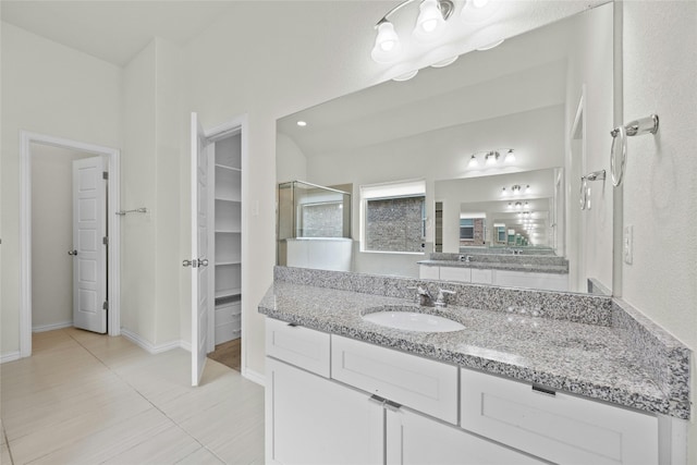 6724 Leonardo Dr, Round Rock, TX 78665 - bathroom featuring vanity, tile patterned floors, a spacious closet, a shower with shower door, and baseboards