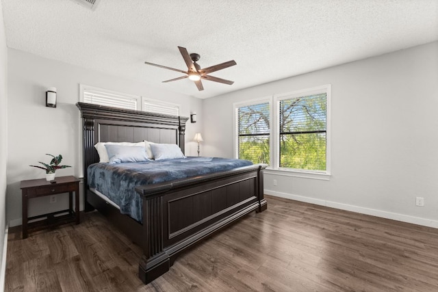 744 Jim Bowie Dr, Spicewood, TX 78669 - bedroom with dark wood-style flooring, a textured ceiling, baseboards, and ceiling fan
