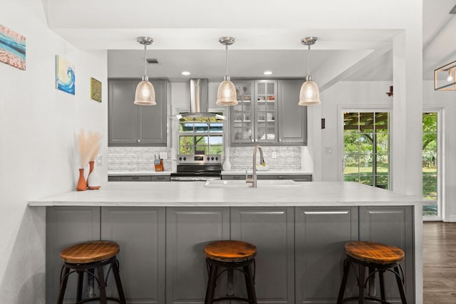 744 Jim Bowie Dr, Spicewood, TX 78669 - kitchen featuring island exhaust hood, stainless steel electric range oven, a sink, gray cabinetry, and tasteful backsplash