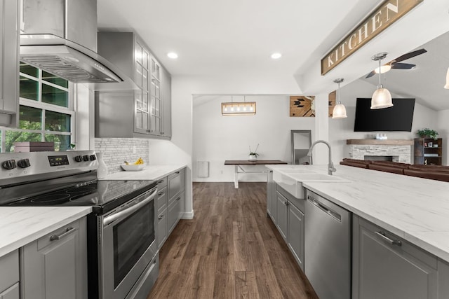 744 Jim Bowie Dr, Spicewood, TX 78669 - kitchen with stainless steel appliances, gray cabinets, wall chimney exhaust hood, a sink, and dark wood-style flooring