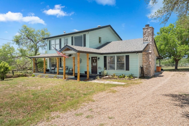 744 Jim Bowie Dr, Spicewood, TX 78669 - view of front facade with a chimney, a shingled roof, a front lawn, covered porch, and driveway
