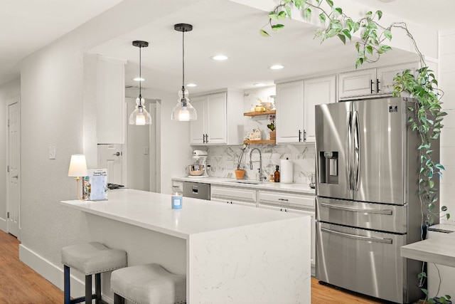 11200 Bending Bough Trl, Austin, TX 78758 - kitchen with appliances with stainless steel finishes, a sink, light wood-type flooring, white cabinetry, and recessed lighting