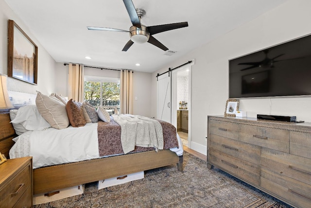 11200 Bending Bough Trl, Austin, TX 78758 - bedroom with a barn door, wood finished floors, recessed lighting, connected bathroom, and ceiling fan