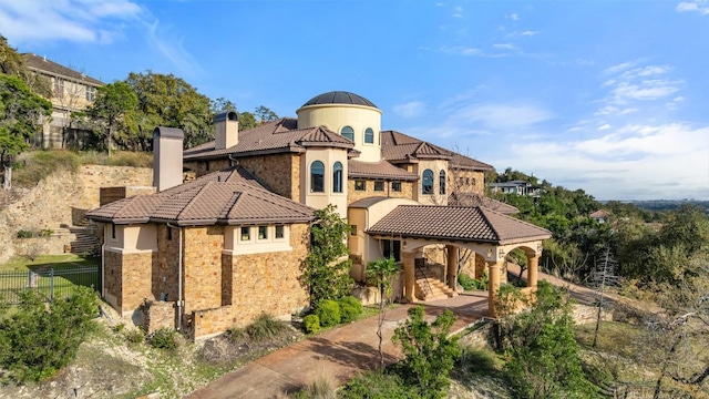 604 Logans Ln, Austin, TX 78746 - rear view of house with a tile roof, a chimney, stone siding, and stucco siding