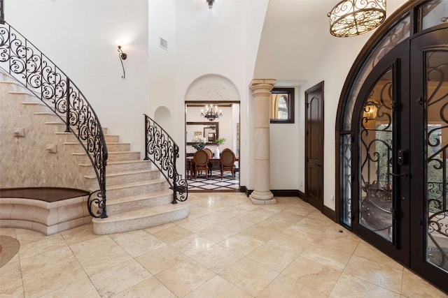 604 Logans Ln, Austin, TX 78746 - entrance foyer with a high ceiling, a chandelier, stairs, french doors, and arched walkways