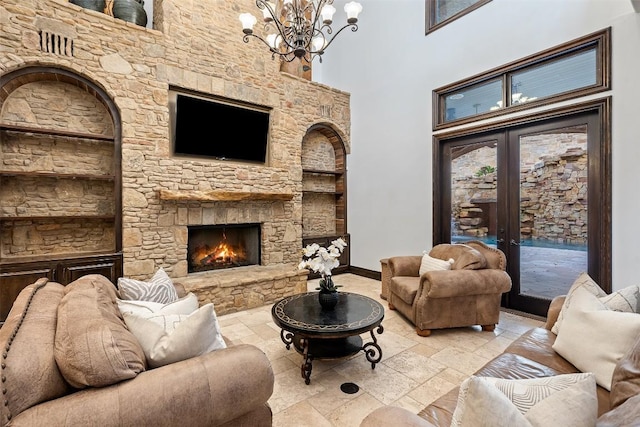604 Logans Ln, Austin, TX 78746 - living room with stone tile flooring, a chandelier, a stone fireplace, and a high ceiling
