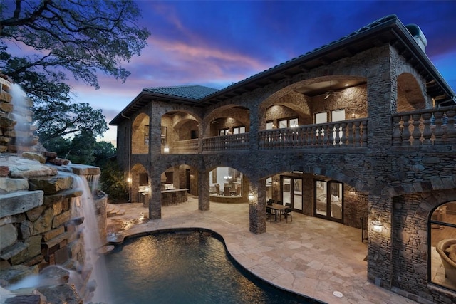 604 Logans Ln, Austin, TX 78746 - rear view of property with a patio area, french doors, stone siding, and a balcony