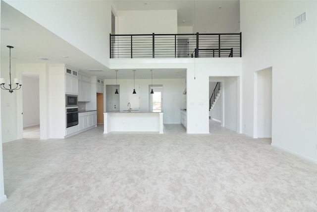 5337 Olimpico Way, Leander, TX 78641 - unfurnished living room featuring a high ceiling, a sink, a chandelier, and light carpet