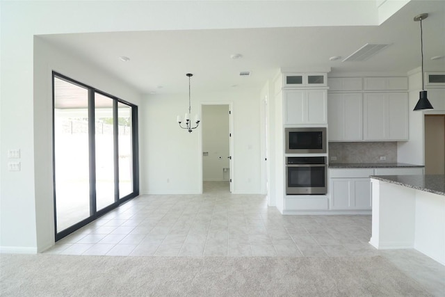 5337 Olimpico Way, Leander, TX 78641 - kitchen featuring stainless steel appliances, a chandelier, decorative backsplash, white cabinets, and light tile patterned floors