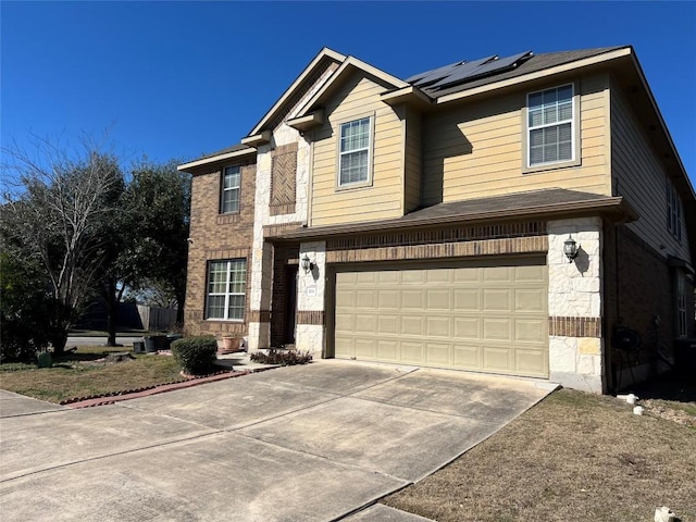 113 Blossom Valley Strm, Buda, TX 78610 - view of front of home with roof mounted solar panels, driveway, an attached garage, and brick siding