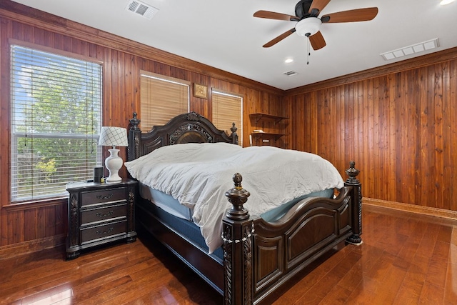 113 Blossom Valley Strm, Buda, TX 78610 - bedroom featuring wood walls, multiple windows, baseboards, dark wood finished floors, and crown molding