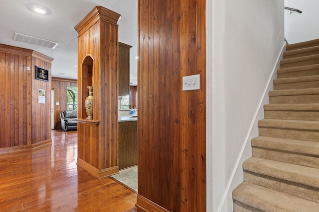 113 Blossom Valley Strm, Buda, TX 78610 - stairs featuring wood finished floors, wooden walls, and baseboards
