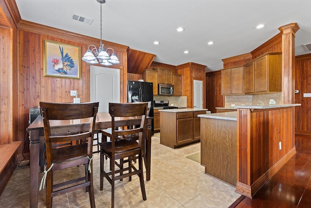113 Blossom Valley Strm, Buda, TX 78610 - kitchen featuring stainless steel appliances, backsplash, a chandelier, wooden walls, and recessed lighting