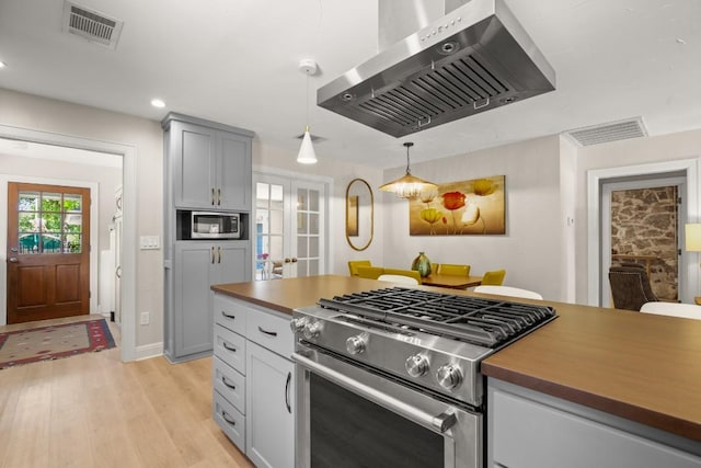 1507 Ash St, Georgetown, TX 78626 - kitchen featuring appliances with stainless steel finishes, island exhaust hood, light wood finished floors, french doors, and recessed lighting