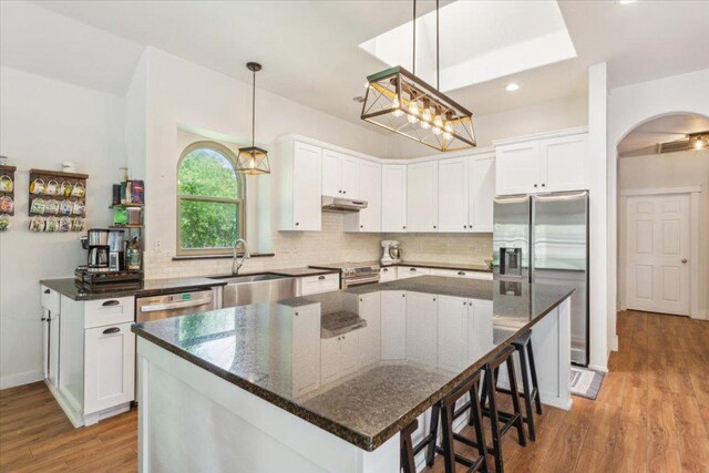 119 Tallwood Cir, Salado, TX 76571 - kitchen featuring appliances with stainless steel finishes, under cabinet range hood, a sink, light wood-type flooring, and white cabinetry