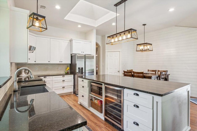 119 Tallwood Cir, Salado, TX 76571 - kitchen featuring beverage cooler, stainless steel refrigerator with ice dispenser, a sink, light wood finished floors, and white cabinets