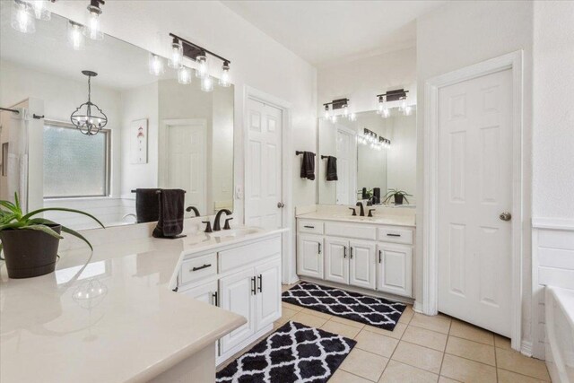 119 Tallwood Cir, Salado, TX 76571 - full bathroom featuring a chandelier, two vanities, tile patterned flooring, a tub to relax in, and a shower