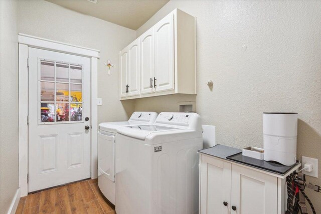 119 Tallwood Cir, Salado, TX 76571 - laundry area featuring cabinet space, washing machine and dryer, light wood finished floors, and a textured wall