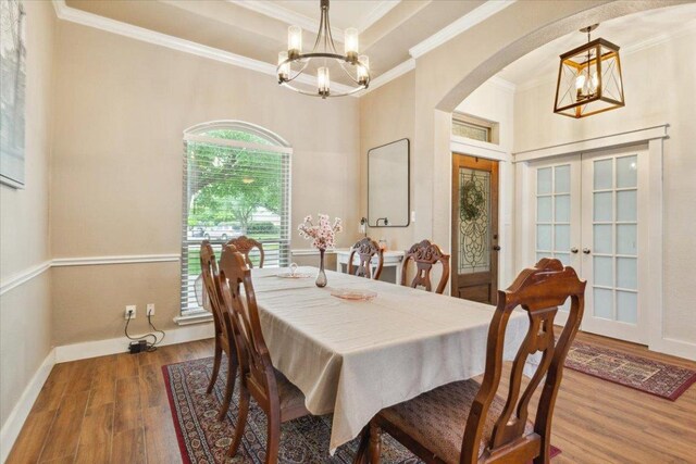 119 Tallwood Cir, Salado, TX 76571 - dining space with a chandelier, arched walkways, wood finished floors, crown molding, and french doors