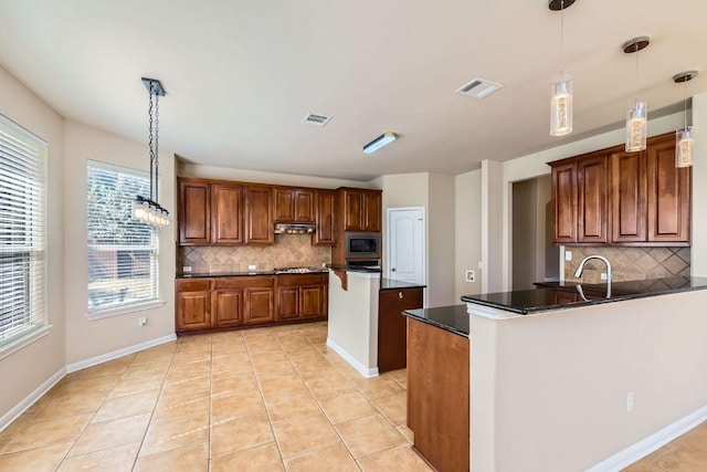 7701 Crackling Creek Dr, Austin, TX 78736 - kitchen featuring stainless steel appliances, backsplash, dark countertops, a peninsula, and a kitchen island