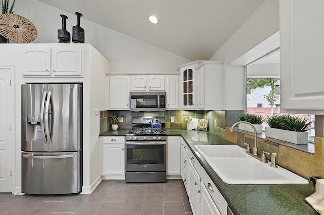 905 Juanita St, Austin, TX 78704 - kitchen with stainless steel appliances, a sink, tile patterned flooring, dark countertops, and glass insert cabinets