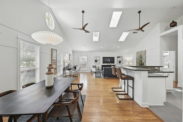 905 Juanita St, Austin, TX 78704 - dining room with ceiling fan, high vaulted ceiling, a skylight, and light wood finished floors