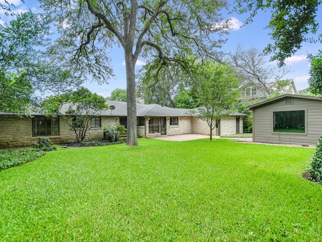 3304 Windsor Rd, Austin, TX 78703 - rear view of house with a patio, a lawn, stone siding, and a garage