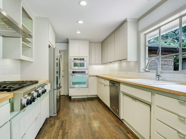 3304 Windsor Rd, Austin, TX 78703 - kitchen with wall chimney exhaust hood, stainless steel appliances, dark wood-style floors, recessed lighting, and tasteful backsplash