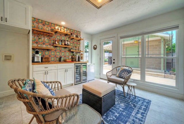 5606 Longhorn Lndg, Austin, TX 78734 - indoor wet bar with beverage cooler, healthy amount of natural light, a textured ceiling, baseboards, and light tile patterned floors