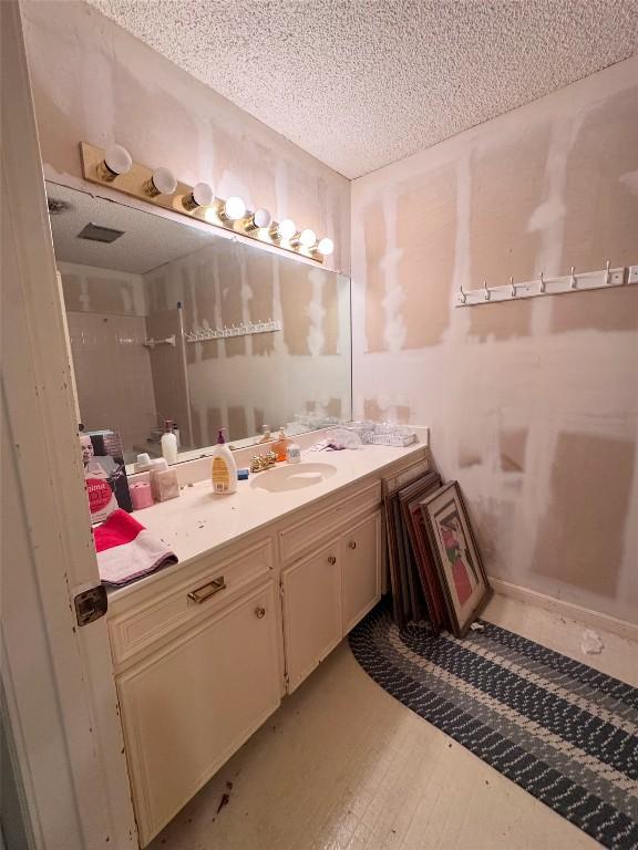 3409 Rosefinch Trl, Austin, TX 78746 - full bathroom featuring vanity, a textured ceiling, and wood finished floors
