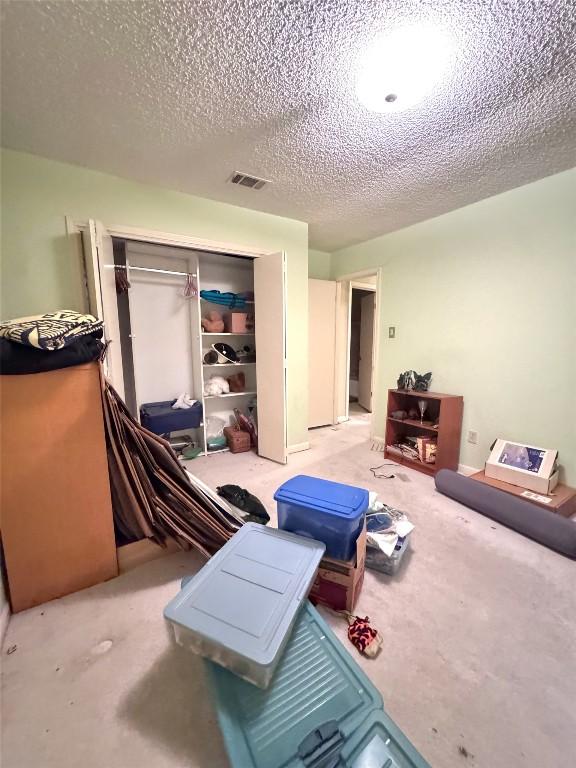 3409 Rosefinch Trl, Austin, TX 78746 - bedroom with light colored carpet, a closet, and a textured ceiling
