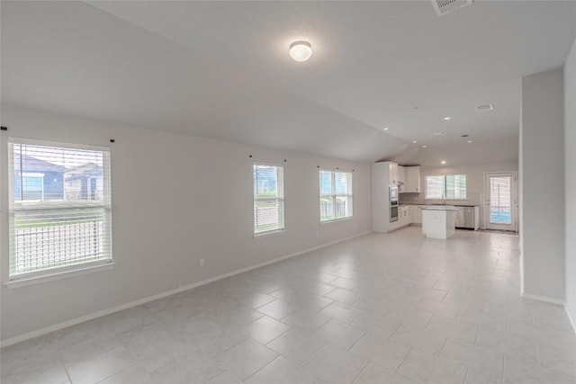 2800 Joe Dimaggio Blvd Unit 95, Round Rock, TX 78665 - unfurnished living room featuring lofted ceiling, baseboards, and light tile patterned flooring