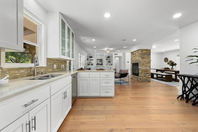 1802 Corona Dr, Austin, TX 78723 - kitchen with stainless steel dishwasher, open floor plan, white cabinetry, recessed lighting, and a stone fireplace