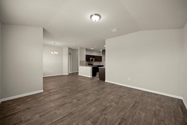 144 Sulphur River Loop, Hutto, TX 78634 - unfurnished living room with a chandelier, dark wood-style flooring, baseboards, recessed lighting, and vaulted ceiling