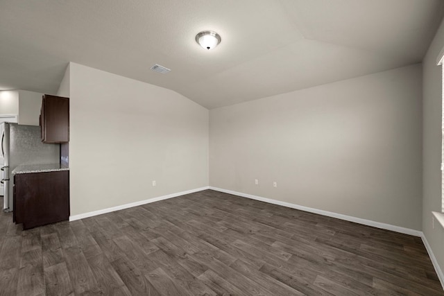 144 Sulphur River Loop, Hutto, TX 78634 - unfurnished living room featuring vaulted ceiling, dark wood finished floors, and baseboards