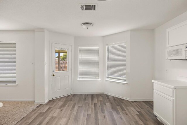 120 Wegstrom St, Hutto, TX 78634 - unfurnished dining area with light wood-style flooring and baseboards