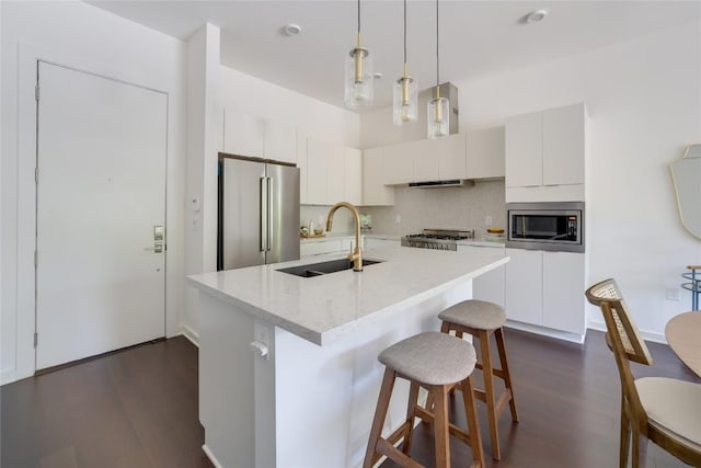 207 W Johanna St Unit 102, Austin, TX 78704 - kitchen featuring appliances with stainless steel finishes, a sink, dark wood-style flooring, and tasteful backsplash