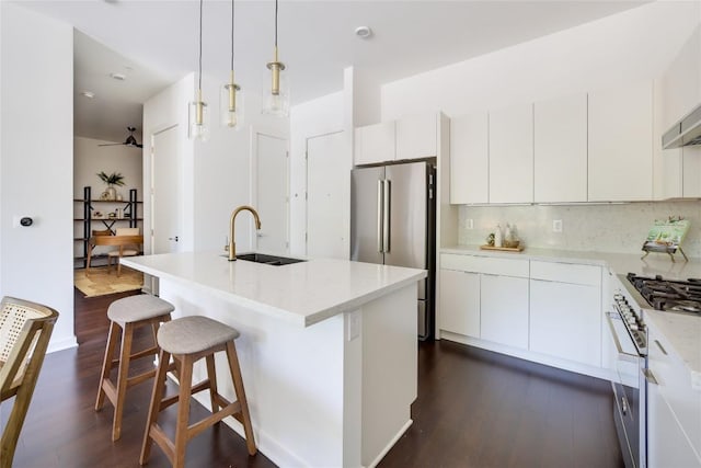 207 W Johanna St Unit 102, Austin, TX 78704 - kitchen with a sink, appliances with stainless steel finishes, dark wood finished floors, white cabinetry, and a breakfast bar area