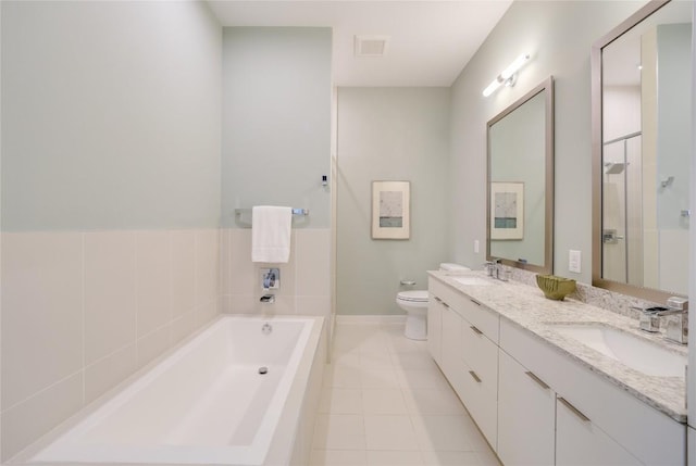 207 W Johanna St Unit 102, Austin, TX 78704 - full bathroom featuring a garden tub, double vanity, toilet, tile patterned flooring, and baseboards