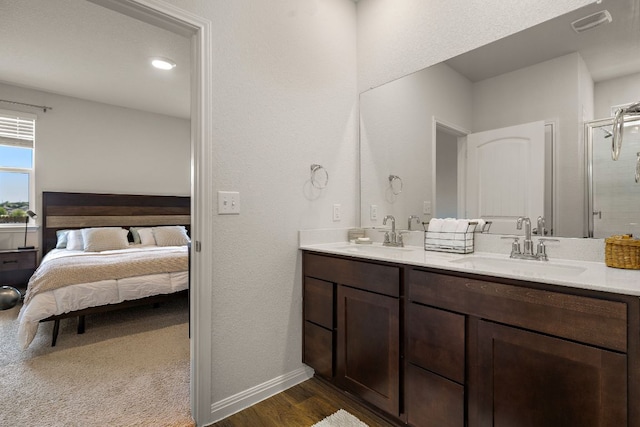 809 Cade Cv, Georgetown, TX 78626 - ensuite bathroom with double vanity, wood finished floors, baseboards, a shower with door, and a textured wall