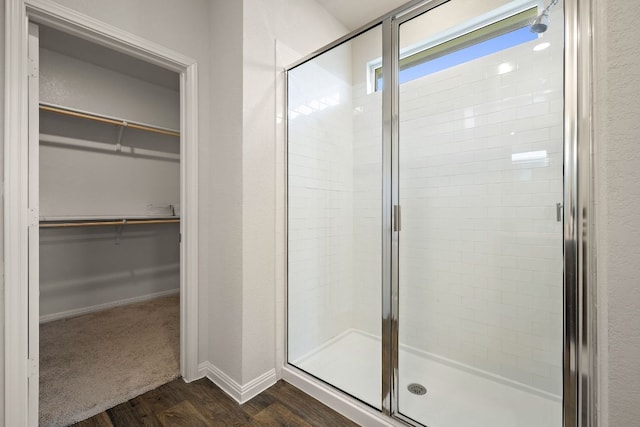 809 Cade Cv, Georgetown, TX 78626 - full bathroom with a shower stall, a walk in closet, wood finished floors, and baseboards