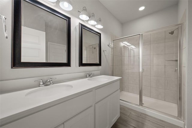 521 Rearing Mare Pass, Georgetown, TX 78626 - bathroom with a stall shower, double vanity, wood finished floors, and recessed lighting
