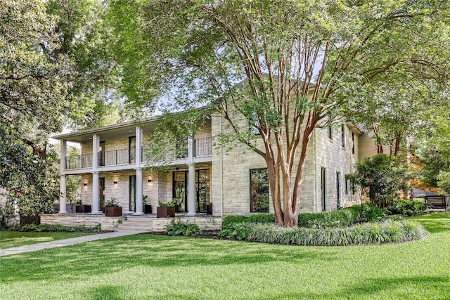 3317 Bowman Ave, Austin, TX 78703 - view of front facade featuring a balcony, stone siding, covered porch, and a front yard