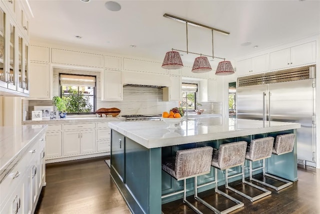 3317 Bowman Ave, Austin, TX 78703 - kitchen with built in refrigerator, white cabinetry, tasteful backsplash, a kitchen breakfast bar, and a center island