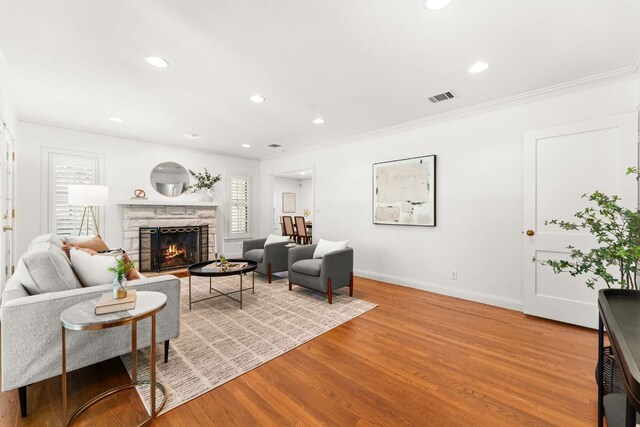 5401 Shoal Creek Blvd, Austin, TX 78756 - living room featuring a stone fireplace, baseboards, light wood-type flooring, recessed lighting, and ornamental molding