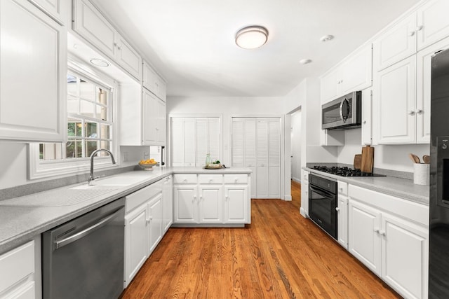 5401 Shoal Creek Blvd, Austin, TX 78756 - kitchen with black appliances, a sink, white cabinetry, and light countertops
